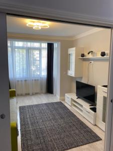 a living room with a television and a living room with a rug at Gabi Apartament in Suceava