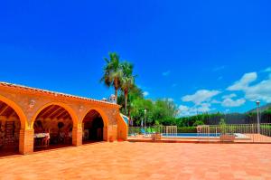 a brick building with a patio and a palm tree at Villa Mika in Jalón