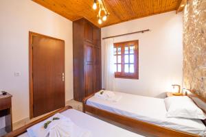 Un dormitorio con dos camas y una ventana. en Villa Yiannitsis - Sunset by the Sea, Acharavi Beach, en Acharavi