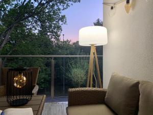 un salon avec un canapé et une lampe sur un balcon dans l'établissement South Part Zamárdi, à Zamárdi