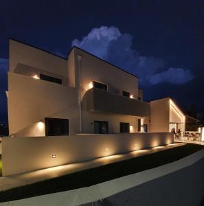 uma grande casa branca com luzes acesas à noite em Solarena Bistrot em Barreiros