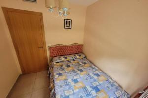 een kleine slaapkamer met een bed en een deur bij Apartamento vacacional Adriana , Montanejos in Montanejos