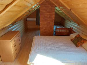 a bedroom with a bed in a attic at Sodyba poilsiui,,Klevas'' in Šilutė