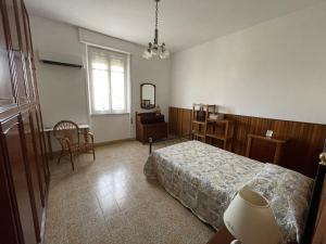 A casa di Pacifica في أتيغليانو: غرفة نوم بسرير وطاولة ونافذة