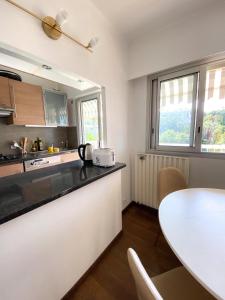 a kitchen with a counter top and a table at Superb Apartment In Cannes With Magnificent View ! in Cannes