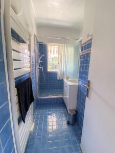 a blue tiled bathroom with a toilet and a sink at Superb Apartment In Cannes With Magnificent View ! in Cannes