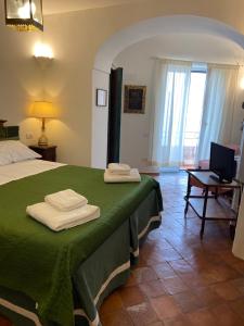 a bedroom with a green bed with a desk and a laptop at La Casa Rossa in Maiori