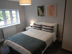 een slaapkamer met een groot bed met 2 kussens bij 27 High Street Apartments in Husbands Bosworth