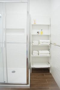 a walk in shower in a bathroom with white towels at South Part Zamárdi in Zamárdi