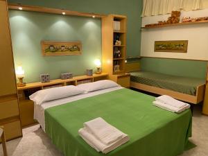 een groene slaapkamer met 2 bedden en handdoeken erop bij Residenza Antico Borgo del Pozzo in Tramonti