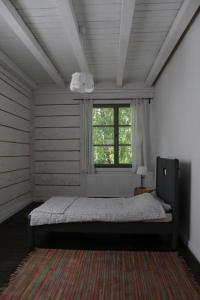 a bedroom with a bed with a window and a rug at Stara Szkola in Potok Senderski