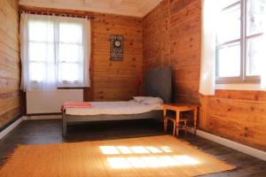 Habitación con cama, mesa y ventanas. en Stara Szkola en Potok Senderski