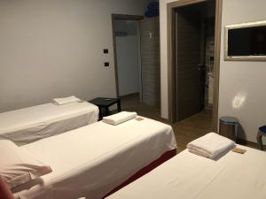 a room with three beds and a television at B&B Magada in Messina