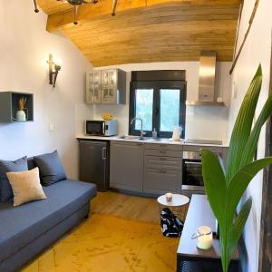 a living room with a blue couch and a kitchen at Casa do Curral do Chapéu in Coja