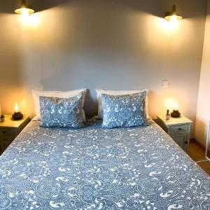 ein blaues Bett mit zwei Kissen darüber in der Unterkunft Casa do Curral do Chapéu in Coja