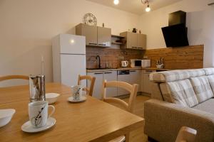 a kitchen and living room with a wooden table and a kitchen and a couch at Apartmán Žacléř 160 / 11 in Žacléř