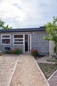a gray house with a door and flowers in front of it at Estate House in Zatoka