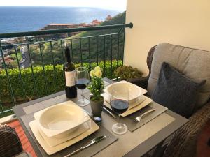 カニコにあるOceanic Apartmentのバルコニーにテーブルとワイン2杯