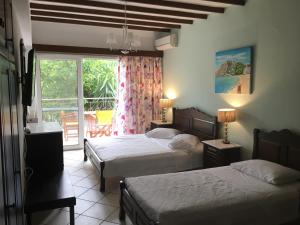 a hotel room with two beds and a balcony at Afrodite Hotel Apartments in Myrina
