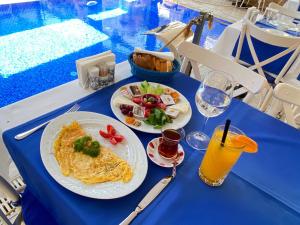 a blue table with two plates of food and a drink at Kervan Hotel in Antalya