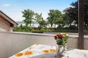 un jarrón de flores sentado en una mesa en un balcón en Gnadenseeblick, en Allensbach