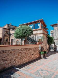 een huis met een balkon aan een bakstenen muur bij Villa al Duomo in Taormina
