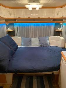 a bed in the middle of a room at Przyczepa Abordaż na Campingu Kormoran in Hel