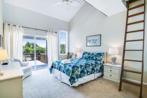 a bedroom with a bed and a desk and a window at Carolina Boulevard 128 in Isle of Palms