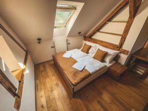 a attic bedroom with a bed with towels on it at Villa Emausy in Luhačovice