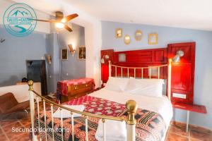 a bedroom with a bed with a red headboard at Calle Horno in Castril +2 photos