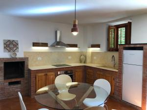 a kitchen with a glass table and white chairs at TORRE MARIZA Guidaloca in Scopello