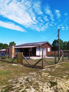 a wooden fence in front of a house at Casa com churrasqueira wi-fi, Tv com Netflix e YouTube in Balneário Gaivotas