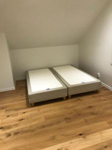 Duas camas num pequeno quarto com pisos em madeira em Videvägen 20 Strömstad em Strömstad