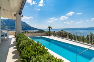 uma piscina com vista para o oceano a partir de uma casa em Seaview Villa Marija with Pool, Jacuzzi, Sauna em Duće