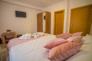 a bedroom with two stuffed animals on a bed with pillows at Užički konak in Užice