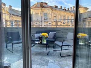 a balcony with chairs and a table with flowers on it at Kuprin Hotel in Odesa