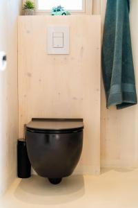 a bathroom with a black toilet in a room at Buqez Resort Villa 46 in Drage