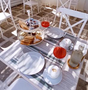 uma mesa com pratos de comida e copos de vinho em B&B La Porta Vecchia em Monopoli
