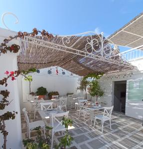 a patio with white tables and white chairs at B&B La Porta Vecchia in Monopoli