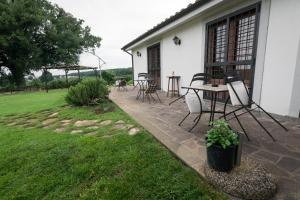 a patio with a table and chairs in a yard at Agriturismo il Poggio in Vetralla
