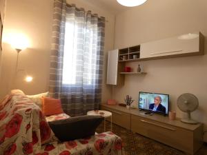 salon z kanapą i telewizorem z płaskim ekranem w obiekcie LA VELA BLU w mieście La Spezia