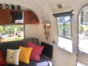 een woonkamer met een bank en kleurrijke kussens bij Private Beach - Port Ludlow Beach Happy Camper in Port Ludlow