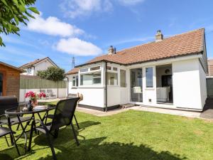 a garden with a table and chairs in front of a house at Summerhayes in Redruth