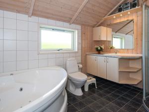 a bathroom with a tub and a toilet and a sink at 8 person holiday home in Hemmet in Hemmet