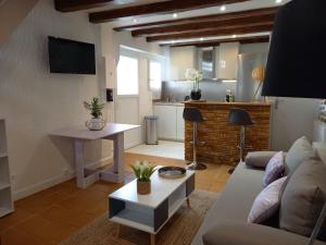 een woonkamer met een bank en een tafel bij Charmante Maison Cosy à Villabé-Hyper Centre-Gare-WIFI in Villabé