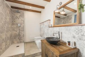 a bathroom with a sink and a toilet and a mirror at B&B Antico Telaio in Santa Maria Navarrese +37 photos