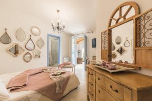 a bedroom with a large mirror and a wooden dresser at B&B Antico Telaio in Santa Maria Navarrese