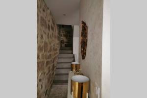 um corredor com escadas e uma luminária dourada em En plein cœur de ville et terrasse tropezienne em Béziers