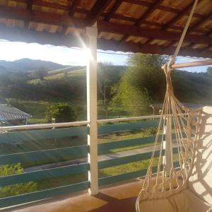 a hammock hanging on a porch with a view at Pousada Vison in Itapeva