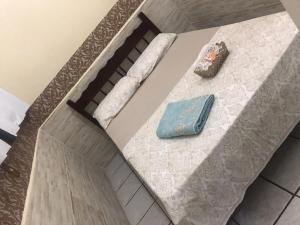 Hospedagem Econômica By Bia في بنها: سرير مع مخده وكتب عليه +84 صورة